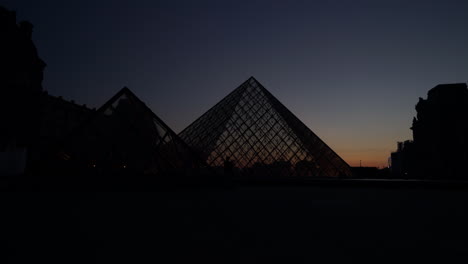 Puesta-De-Sol-Sobre-El-Museo-Del-Louvre,-París-Francia,-Lapso-De-Tiempo-Sobre-La-Icónica-Pirámide-De-Cristal