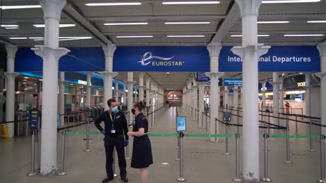 Staff-welcome-travellers-at-the-entrance-to-the-Eurostar-in-Kings-Cross-St-Pancras,-London,-UK