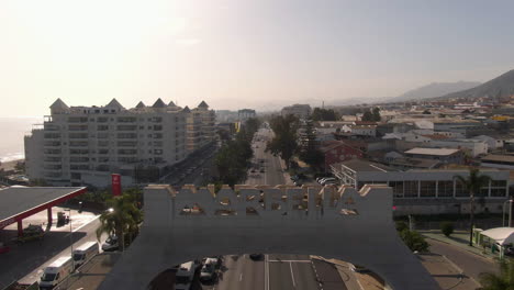 Aerial-descent-revealing-Marbella-sign-with-city-and-sun-in-background