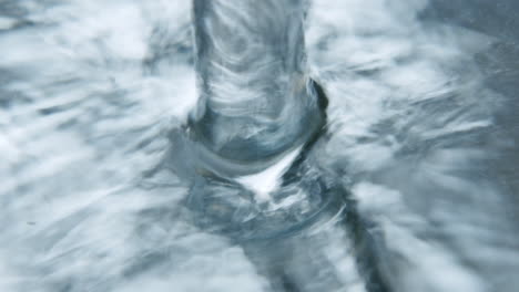 Macro-slow-motion-shot-of-water-splashing-onto-a-shiny-surface
