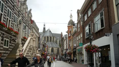 Static-shot-of-strolling-pedestrians-and-famous-dutch-cathedral-in-background,Alkmaar-Netherlands