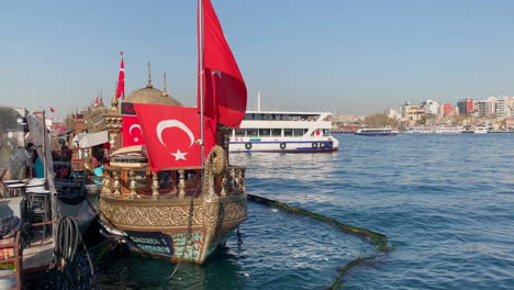 Barco-Antiguo-Con-Banderas-Nacionales-Turcas-Flotando-En-El-Agua-En-La-Terminal-De-Ferry-Eminönü-En-Estambul