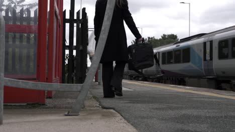 Business-woman-waiting-at-train-station-while-train-goes-by
