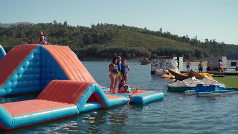 People-Enjoying-Summer-Outdoors,-Playing-And-Taking-Pictures-At-Inflatable-Water-Park-In-Teleski-Ermal,-Vieira-Do-Minho,-Portugal---Wide-Shot