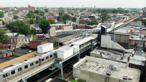 SEPTA-subway-train-stops-at-Kensington,-aerial-view-of-North-Philly-city-famous-for-opioid-addicts-and-crime