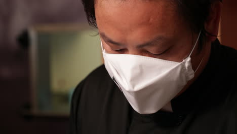 Sushi-Chef-Wearing-A-White-Face-Mask-While-Preparing-A-Dish-At-The-Restaurant