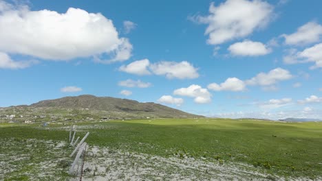 Motion-Timelapse-Of-Fluffy-White-Clouds-Moving-In-The-Bright-Blue-Sky-Over-The-Lush-Mountain-Near-Dog's-Bay-Beach-In-Connemara,-Ireland---ground-level-shot
