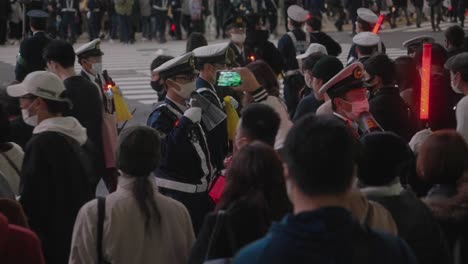 Uniformierte-Polizisten-Mit-Masken-Kontrollieren-Die-Menschenmenge-In-Den-Gebieten-Um-Den-Shibuya-Kreuzung-Während-Des-Halloween-Nachtfestivals-2020-In-Tokio,-Japan-–-Zeitlupe