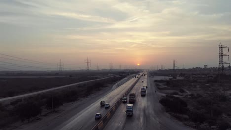 Luftaufnahme-Des-Verkehrs,-Der-Bei-Sonnenuntergang-Auf-Der-Autobahn-Von-Karachi-Nach-Hyderabad-Fährt