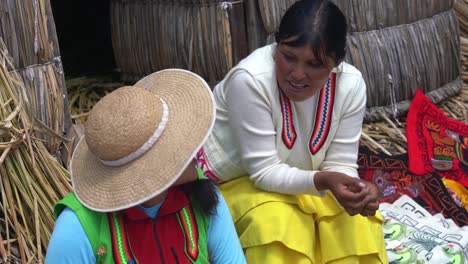 Front-view-of-two-Uru-women-talking-in-traditional-clothes-in-Isla-del-Sol,-day
