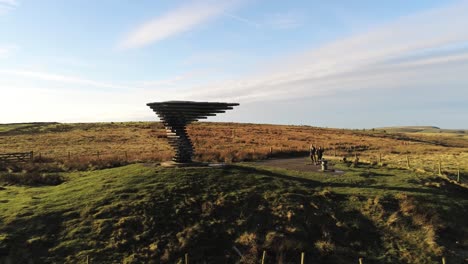 Aerial-singing-ringing-tree-musical-panopticon-sculpture-in-Lancashire-hiking-countryside-slow-orbit-right-low-shot-sunrise