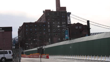 Gentrifizierung-Am-Arbeitsplatz,-Autos-Und-Biker-Fahren-Vorbei,-Sanierung-Einer-Domino-Fabrik-In-Williamsburg,-Brooklyn