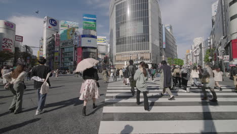 Eine-Menschenmenge-überquert-An-Einem-Sonnigen-Sommertag-Während-Einer-Pandemie-In-Tokio,-Japan,-Den-Shibuya-Kreuzung