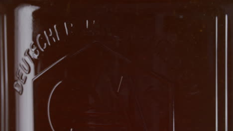 Close-up-of-glowing-honey-jar-on-black-background,-static-shot
