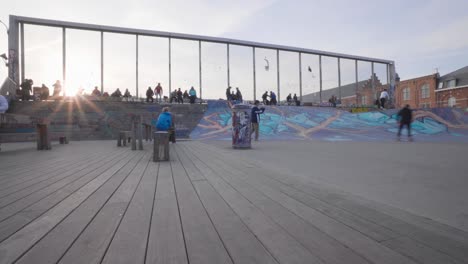 Skater-does-a-trick,-jump-on-skateboard-in-the-air,-practice-ollie-in-urban-skate-park,-Brussels,-Belgium