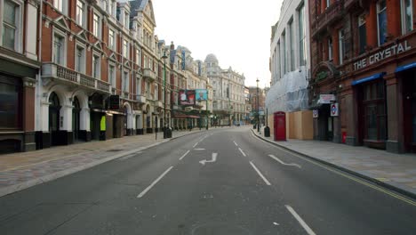 Lockdown-in-London,-slow-motion-gimbal-walk-along-empty-Shaftesbury-Avenue-with-closed-theatres-and-restaurants,-during-the-Coronavirus-pandemic-2020