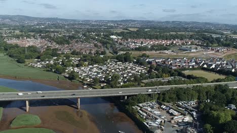 Aerial-of-a-motorway-flyover-and-the-village-of-Topsham-in-the-foreground-with-the-city-of-Exeter-in-the-distance