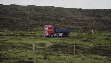 Toma-De-Seguimiento-En-Cámara-Lenta-De-La-Conducción-De-Camiones-Entre-Colinas-Verdes-En-Las-Islas-Feroe-Durante-Las-Nubes-En-El-Cielo