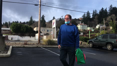 An-Old-Man-From-Parking-Lot-Walking-Towards-A-Natural-Grocers-Store-At-Coos-Bay,-Oregon