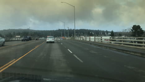 Conduciendo-A-Través-De-La-Autopista-101-De-La-Ciudad-Moderna-Contra-El-Cielo-Nublado-En-Coos-Bay,-Oregon