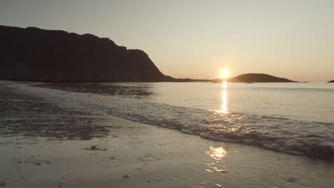 Sanfte-Kamerafahrt-Der-Wellen-Am-Strand-Der-Lofoten-In-Norwegen-Mit-Dem-Sonnenuntergang-Im-Hintergrund