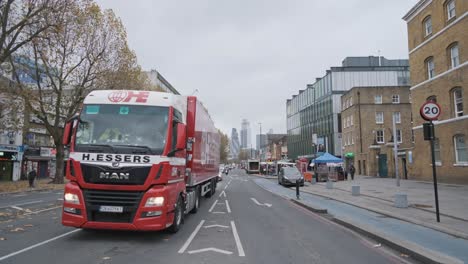 Coches-Circulando-Por-London-Whitechapel-Road-Con-El-Centro-De-La-Ciudad-En-El-Fondo-De-Par-En-Par