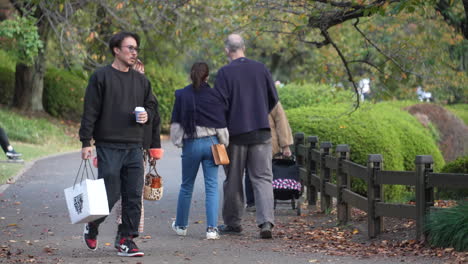 Gente-Caminando-Y-Disfrutando-De-La-Hermosa-Vista-Alrededor-Del-Parque-Nacional-Shinjuku-Gyoen-En-Tokio,-Japón---Tiro-Medio,-Cámara-Lenta