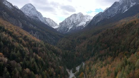 Aerial-drone-flying-between-mountain-peaks-green-forest-autumn-day