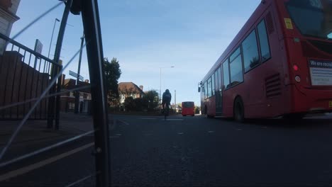 Low-Angle-POV-Cycling-On-Park-Way-Road-With-Red-Bus-Turning-Right-In-Ruislip-Manor