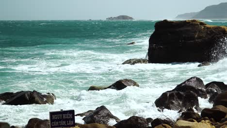 Turquoise-sea-waves-crush-on-rocks-of-Hang-Rai-coast,-Vietnam