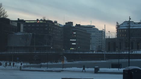 Day-to-night-time-lapse-in-Helsinki-Central-Library-Square,-starting-on-a-winter-snowy-day