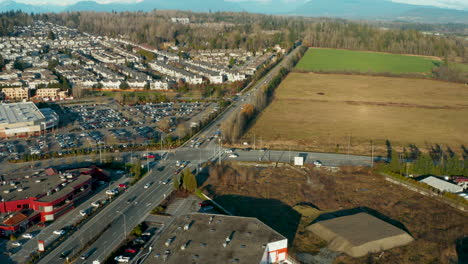 Aerial-flying-over-farm-fields-and-suburban-development-in-Langley,-BC