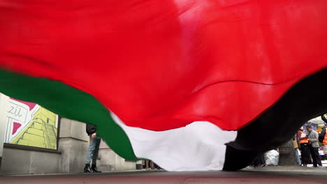 A-large-Palestinian-flag-is-waved-just-off-the-ground-at-a-protest-against-Israeli-military-action-on-Gaza