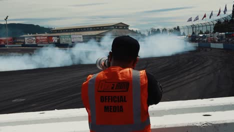 Hombre-Tomando-Fotos-De-Un-Automóvil-A-La-Deriva-Alrededor-De-La-Pista-En-Driftcon