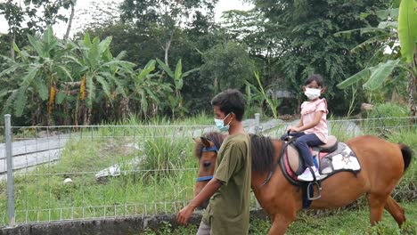 Yogyakarta,-Indonesia---May-18,-2021-:-a-girl-is-enjoying-riding-a-horse-in-a-park