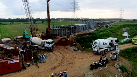 Monorail-construction-site-on-Java,-trucks-deliver-concrete-for-foundation