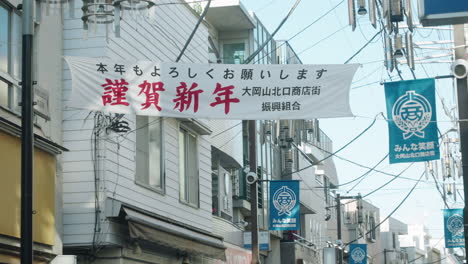Japanese-New-Year-Greetings-Banner-Hanged-Over-The-Street-On-Celebration-Of-New-Year-Day-In-Tokyo,-Japan