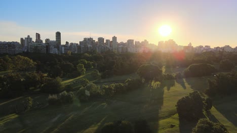 Luftwagen-Aus-Dem-Städtischen-Golfplatz-Mit-Der-Skyline-Des-Stadtteils-Palermo-Im-Hintergrund-Bei-Sonnenuntergang,-Buenos-Aires
