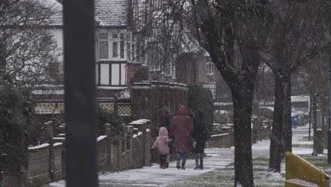 Mutter-Läuft-Mit-Kindern-Auf-Dem-Bürgersteig,-Während-Es-Schneit