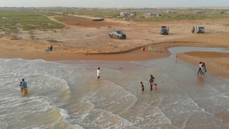 Aerial-Parallax-Of-Tourists-At-Damb-Beach-Waters-In-Balochistan