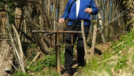 Turn-style-Cattle-barrier-placed-by-the-exit-and-entrance-at-the-forest-in-Austria-with-a-man-passing-through