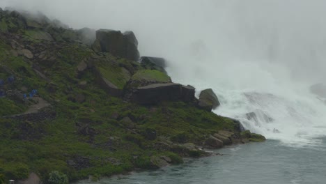 Wasser-Sprudelt-Den-Wasserfall-Hinunter,-Umgeben-Von-Großen-Felsen