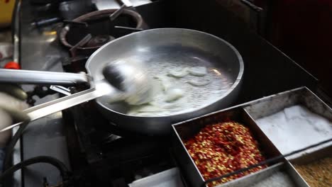 Professional-chef-fries-vegetables-to-prepare-white-sauce-Pasta-at-a-street-food-shop-at-Chat-Gali-in-Agra,-India-on-07-March-2021