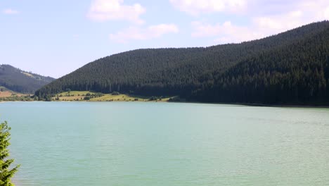 Türkisblaues-Wasser-Des-Ruhigen-Sees-Am-Fuße-Der-Bergkette