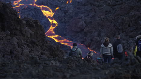 Group-of-visitors-enjoying-incredible-view-of-flowing-magma-down-the-Geldingadalir-Volcano-in-Iceland-during-evening