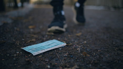 Slomo-of-unrecognizable-young-man-picking-up-face-mask-from-ground