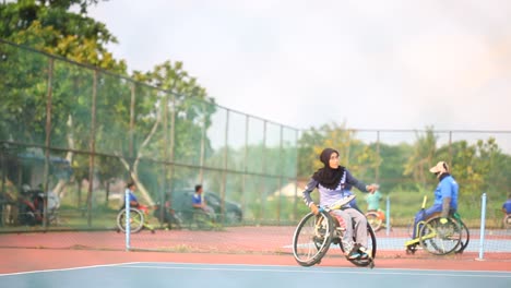 Yogyakarta,-Indonesien---2.-Mai-2021:-Verschleierte-Asiatin-Im-Rollstuhl,-Die-Auf-Dem-Platz-Tennis-Spielt
