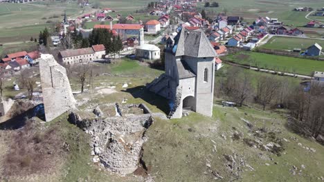 Sunny-winter-day-an-areal-view-on-a-picturesque-village-with-a-castle-on-top-of-the-hill