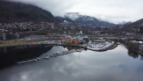 Wunderschöne-Malerische-Rotierende-Antenne-Vom-Meer-Des-Stadtzentrums-Von-Arna-Bei-Wetterwechsel-Mit-Erstaunlich-Hellen-Wasserreflexionen---Einkaufszentrum-Øyrane-Torg---Norwegen