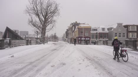 Lugareños-Holandeses-En-Bicicleta-Por-Las-Nevadas-Carreteras-De-La-Ciudad-De-Leiden,-Invierno-De-Los-Países-Bajos